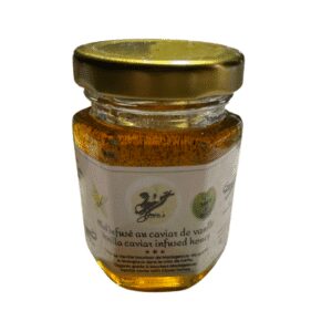 A small jar of honey with a gold lid and a label on the front.